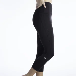 A woman wearing Entensa’s black capri performance leggings stands in a side profile pose against a bright white studio background. The leggings feature a high-rise waistband and a sleek, sculpted fit that highlights the leg contour. Designed for movement and everyday performance, these women’s athletic leggings reflect Entensa’s commitment to combining strength, style, and purpose.
